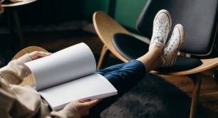 Person in jeans holding white notebook